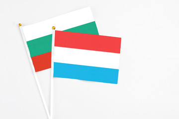 Luxembourg and Bulgaria stick flags on white background. High quality fabric, miniature national flag. Peaceful global concept.White floor for copy space.