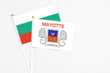 Mayotte and Bulgaria stick flags on white background. High quality fabric, miniature national flag. Peaceful global concept.White floor for copy space.
