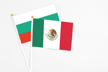 Mexico and Bulgaria stick flags on white background. High quality fabric, miniature national flag. Peaceful global concept.White floor for copy space.