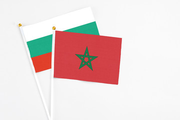 Morocco and Bulgaria stick flags on white background. High quality fabric, miniature national flag. Peaceful global concept.White floor for copy space.