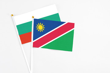 Namibia and Bulgaria stick flags on white background. High quality fabric, miniature national flag. Peaceful global concept.White floor for copy space.