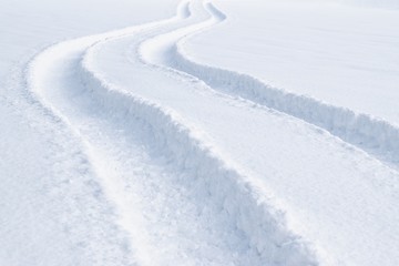 Fototapeta na wymiar Car tracks in the deep fresh snow