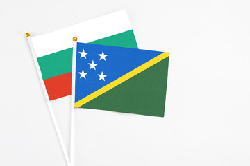 Solomon Islands and Bulgaria stick flags on white background. High quality fabric, miniature national flag. Peaceful global concept.White floor for copy space.