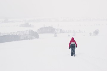 Man walking alone within a heavy snowfall