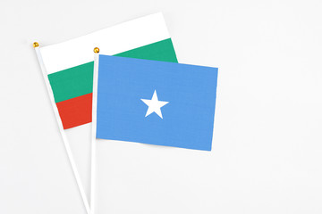 Somalia and Bulgaria stick flags on white background. High quality fabric, miniature national flag. Peaceful global concept.White floor for copy space.