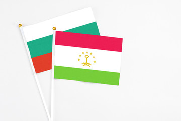 Tajikistan and Bulgaria stick flags on white background. High quality fabric, miniature national flag. Peaceful global concept.White floor for copy space.