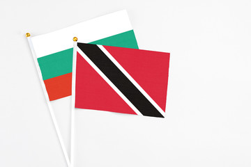 Trinidad And Tobago and Bulgaria stick flags on white background. High quality fabric, miniature national flag. Peaceful global concept.White floor for copy space.