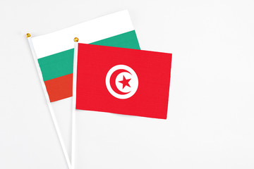 Tunisia and Bulgaria stick flags on white background. High quality fabric, miniature national flag. Peaceful global concept.White floor for copy space.