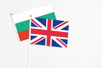 Fototapeta premium United Kingdom and Bulgaria stick flags on white background. High quality fabric, miniature national flag. Peaceful global concept.White floor for copy space.