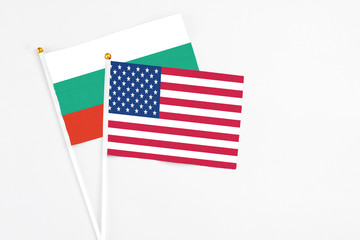 United States and Bulgaria stick flags on white background. High quality fabric, miniature national flag. Peaceful global concept.White floor for copy space.