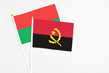 Angola and Burkina Faso stick flags on white background. High quality fabric, miniature national...