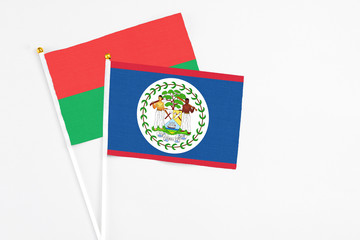 Belize and Burkina Faso stick flags on white background. High quality fabric, miniature national flag. Peaceful global concept.White floor for copy space.