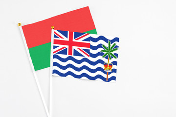 Fototapeta premium British Indian Ocean Territory and Burkina Faso stick flags on white background. High quality fabric, miniature national flag. Peaceful global concept.White floor for copy space.