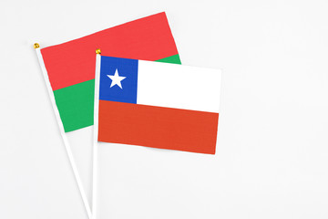 Chile and Burkina Faso stick flags on white background. High quality fabric, miniature national flag. Peaceful global concept.White floor for copy space.