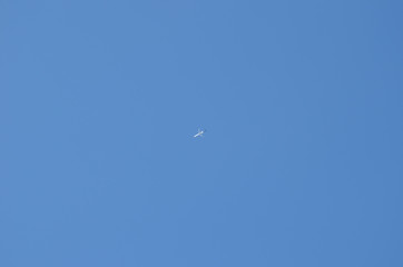 Blue autumn sky with flying plane. 