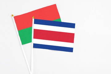 Costa Rica and Burkina Faso stick flags on white background. High quality fabric, miniature national flag. Peaceful global concept.White floor for copy space.