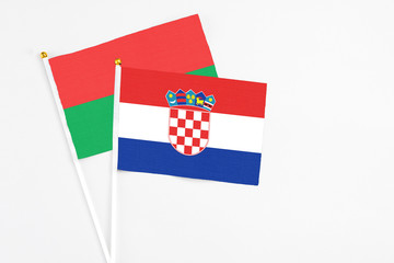 Croatia and Burkina Faso stick flags on white background. High quality fabric, miniature national flag. Peaceful global concept.White floor for copy space.