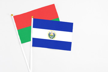 El Salvador and Burkina Faso stick flags on white background. High quality fabric, miniature national flag. Peaceful global concept.White floor for copy space.