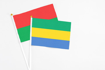 Gabon and Burkina Faso stick flags on white background. High quality fabric, miniature national flag. Peaceful global concept.White floor for copy space.