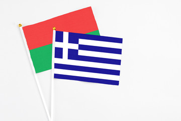 Greece and Burkina Faso stick flags on white background. High quality fabric, miniature national flag. Peaceful global concept.White floor for copy space.