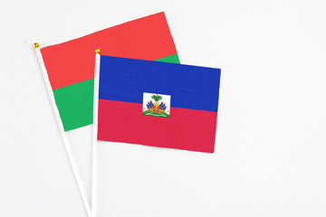 Haiti and Burkina Faso stick flags on white background. High quality fabric, miniature national flag. Peaceful global concept.White floor for copy space.