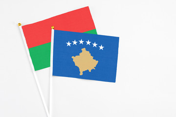 Kosovo and Burkina Faso stick flags on white background. High quality fabric, miniature national flag. Peaceful global concept.White floor for copy space.