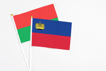 Liechtenstein and Burkina Faso stick flags on white background. High quality fabric, miniature national flag. Peaceful global concept.White floor for copy space.