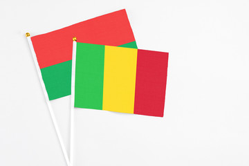 Mali and Burkina Faso stick flags on white background. High quality fabric, miniature national flag. Peaceful global concept.White floor for copy space.