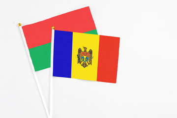 Moldova and Burkina Faso stick flags on white background. High quality fabric, miniature national flag. Peaceful global concept.White floor for copy space.