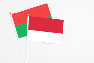 Monaco and Burkina Faso stick flags on white background. High quality fabric, miniature national flag. Peaceful global concept.White floor for copy space.