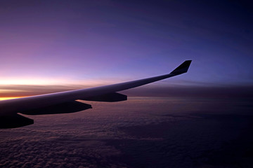 Fototapeta na wymiar Plane, aeroplane wing, clouds, gradient sky from aerial view