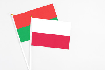Poland and Burkina Faso stick flags on white background. High quality fabric, miniature national flag. Peaceful global concept.White floor for copy space.