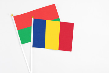 Romania and Burkina Faso stick flags on white background. High quality fabric, miniature national flag. Peaceful global concept.White floor for copy space.