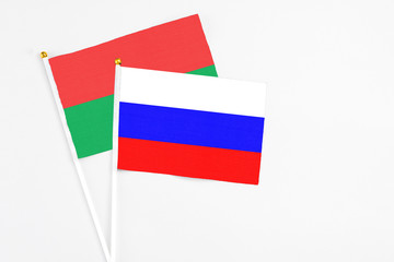 Russia and Burkina Faso stick flags on white background. High quality fabric, miniature national flag. Peaceful global concept.White floor for copy space.