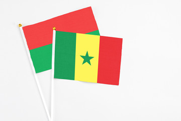 Senegal and Burkina Faso stick flags on white background. High quality fabric, miniature national flag. Peaceful global concept.White floor for copy space.