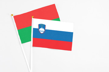 Slovenia and Burkina Faso stick flags on white background. High quality fabric, miniature national flag. Peaceful global concept.White floor for copy space.