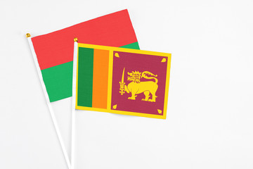 Sri Lanka and Burkina Faso stick flags on white background. High quality fabric, miniature national flag. Peaceful global concept.White floor for copy space.