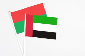 United Arab Emirates and Burkina Faso stick flags on white background. High quality fabric, miniature national flag. Peaceful global concept.White floor for copy space.