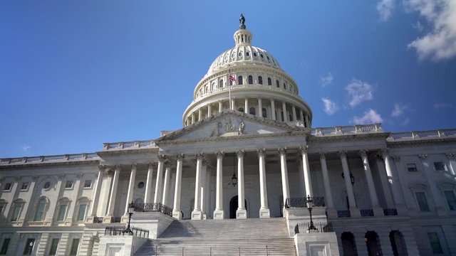 US Capitol dome against blue cloudless sky with camera turning.