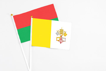 Vatican City and Burkina Faso stick flags on white background. High quality fabric, miniature national flag. Peaceful global concept.White floor for copy space.