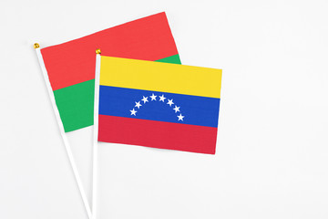 Venezuela and Burkina Faso stick flags on white background. High quality fabric, miniature national flag. Peaceful global concept.White floor for copy space.