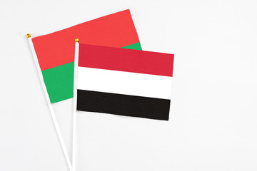 Yemen and Burkina Faso stick flags on white background. High quality fabric, miniature national flag. Peaceful global concept.White floor for copy space.