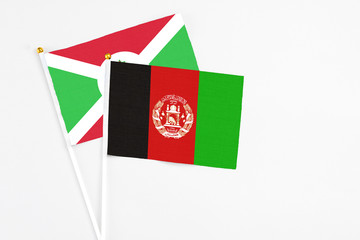 Afghanistan and Burundi stick flags on white background. High quality fabric, miniature national flag. Peaceful global concept.White floor for copy space.