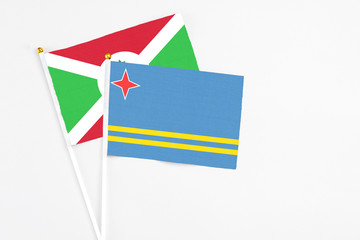 Aruba and Burundi stick flags on white background. High quality fabric, miniature national flag. Peaceful global concept.White floor for copy space.