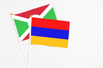 Armenia and Burundi stick flags on white background. High quality fabric, miniature national flag. Peaceful global concept.White floor for copy space.