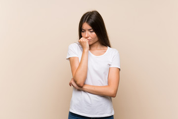 Pretty young girl over isolated background having doubts