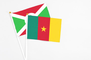 Cameroon and Burundi stick flags on white background. High quality fabric, miniature national flag. Peaceful global concept.White floor for copy space.