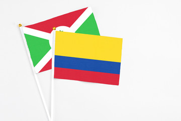 Colombia and Burundi stick flags on white background. High quality fabric, miniature national flag. Peaceful global concept.White floor for copy space.