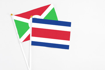 Costa Rica and Burundi stick flags on white background. High quality fabric, miniature national flag. Peaceful global concept.White floor for copy space.