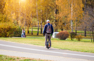 Man rides unicycle scooter for city Park. © licvin